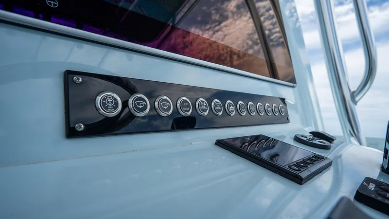 Slide: The Image of Control panel of 2024 Contender 24 Sport boat with modern buttons and sleek design. - 23
