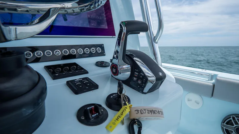 Slide: The Image of 2024 Contender 24 Sport boat controls with ocean view in the background. - 25