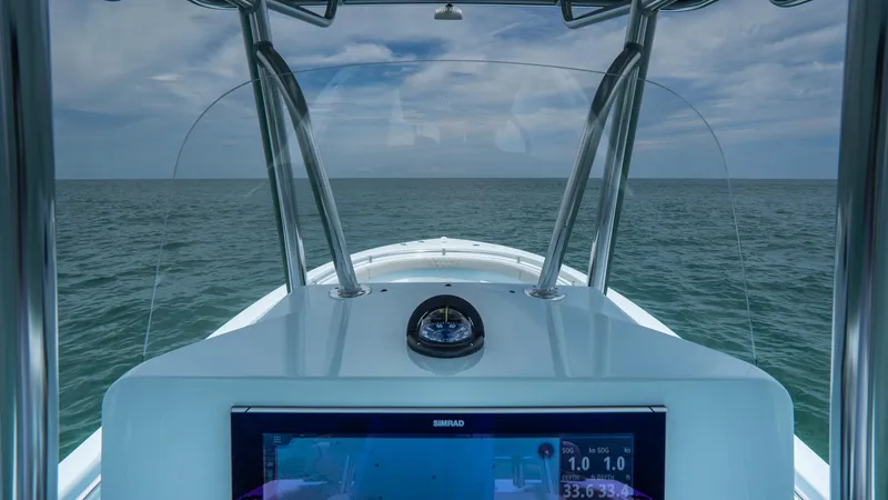 Slide: The Image of 2024 Contender 24 Sport boat dashboard with ocean view and navigation display. - 27