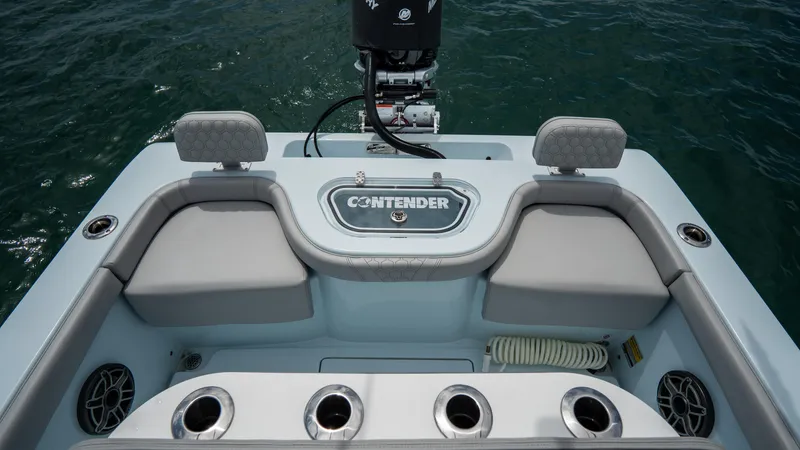 Slide: The Image of 2024 Contender 24 Sport boat interior with seating and motor, on open water. - 29