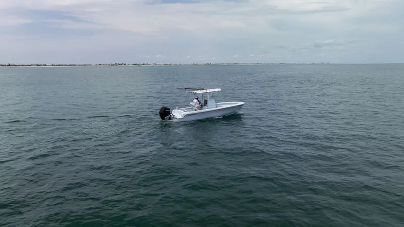 Slide: The Image of 2024 Contender 24 Sport boat cruising on open water under a cloudy sky. - 3
