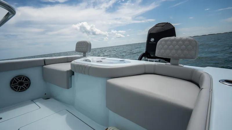 Slide: The Image of 2024 Contender 24 Sport boat interior with cushioned seating and ocean view. - 30