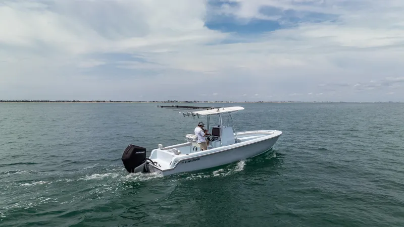 Slide: The Image of 2024 Contender 24 Sport boat cruising on open water under a cloudy sky. - 4