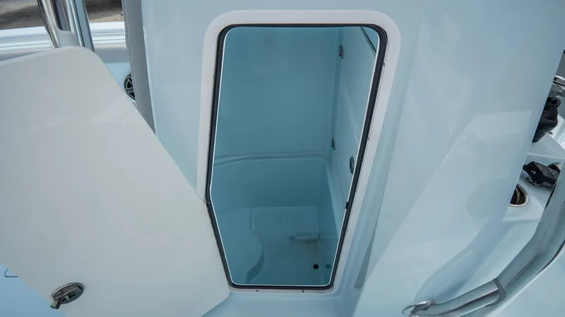 Slide: The Image of 2024 Contender 24 Sport boat interior storage compartment with open door. - 40