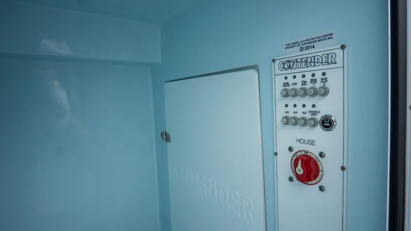 Slide: The Image of Control panel of 2024 Contender 24 Sport boat, featuring switches and a red dial. - 41