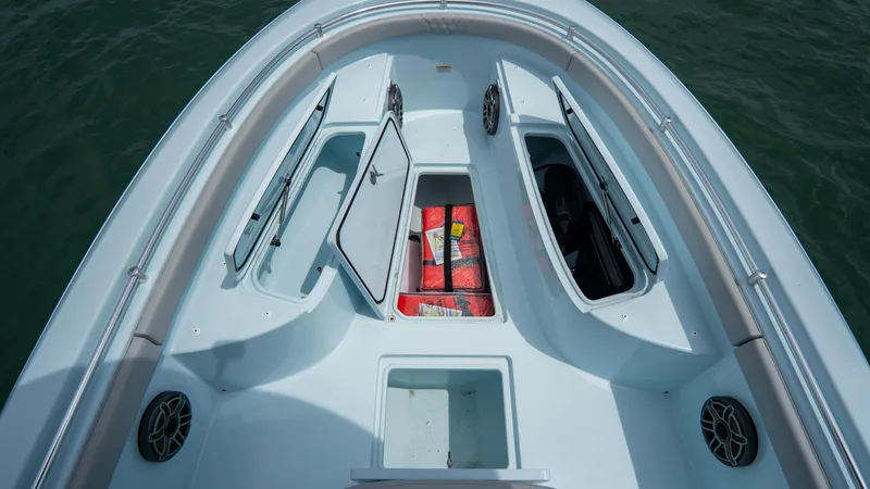 Slide: The Image of 2024 Contender 24 Sport boat deck with open storage compartments and speakers. - 8