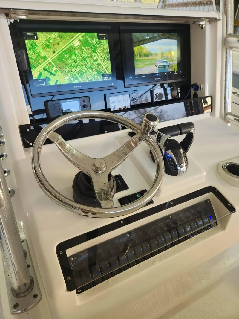 Slide: The Image of Control panel of 2013 Invincible 36 Open Fisherman with navigation screens and steering wheel. - 12