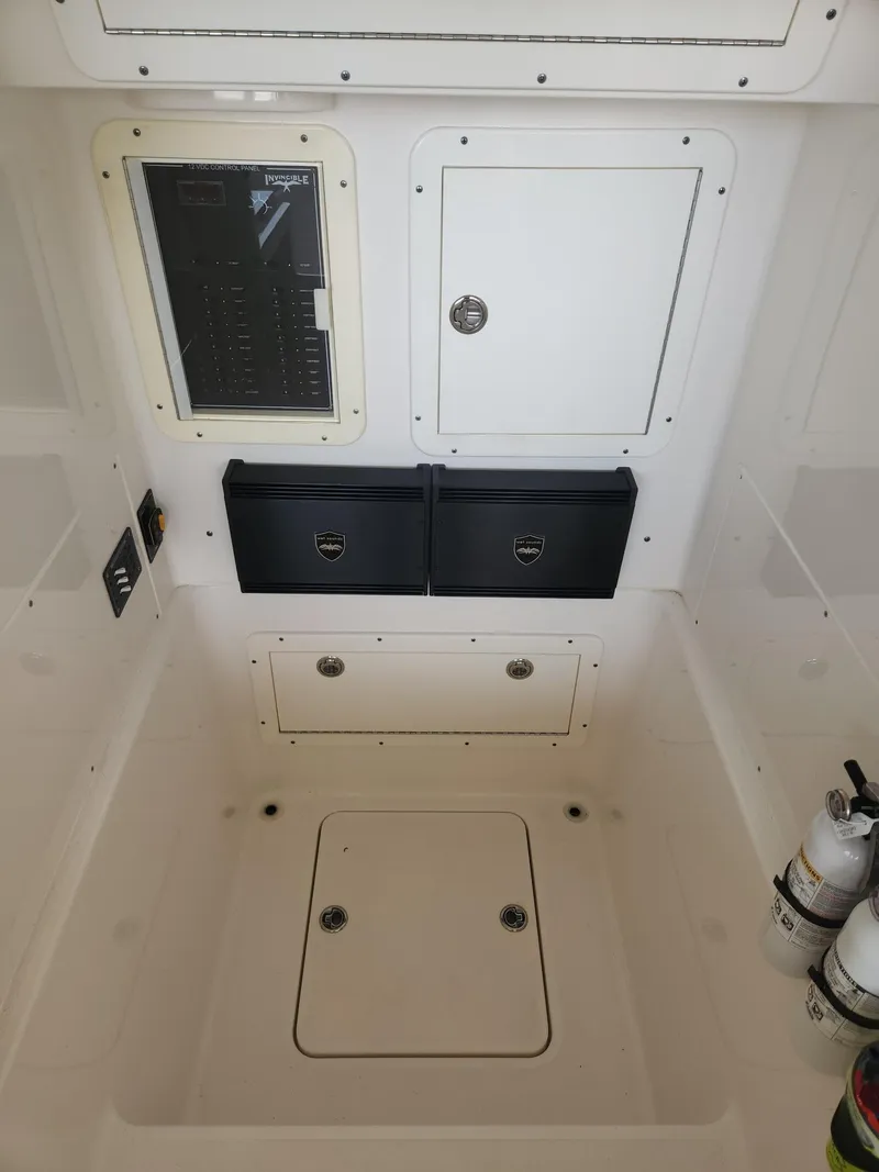 Slide: The Image of 2013 Invincible 36 Open Fisherman interior with storage compartments and control panel. - 15