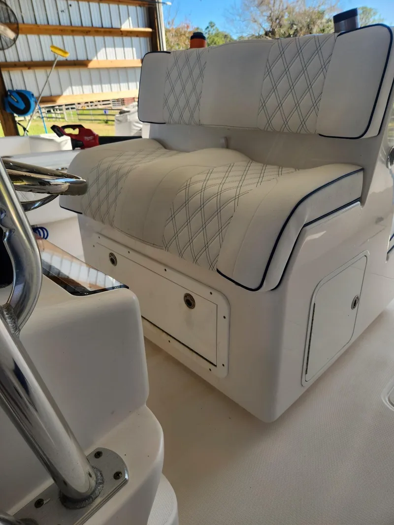 Slide: The Image of 2013 Invincible 36 Open Fisherman boat with cushioned seating in a covered storage area. - 18