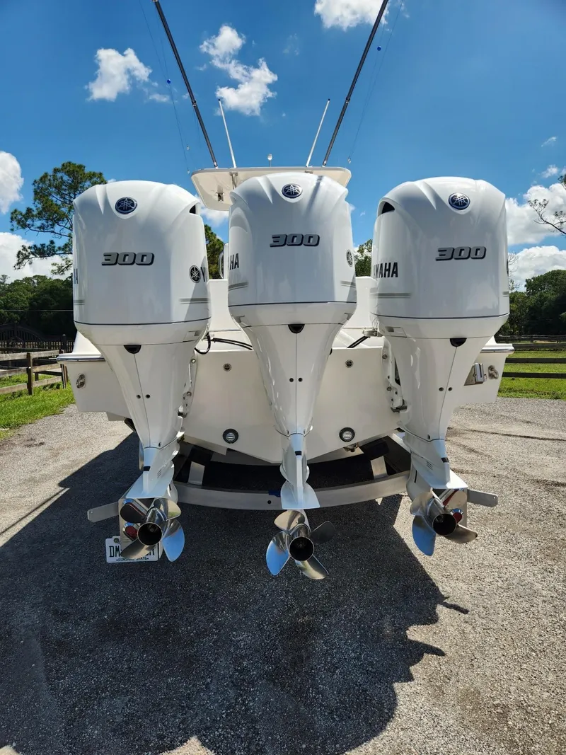 Slide: The Image of 2013 Invincible 36 Open Fisherman with triple Yamaha 300 engines, parked outdoors. - 20