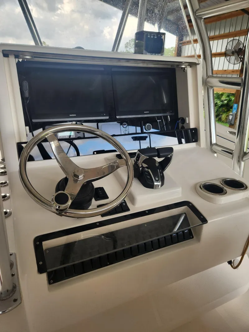 Slide: The Image of 2013 Invincible 36 Open Fisherman boat helm with steering wheel and controls. - 28