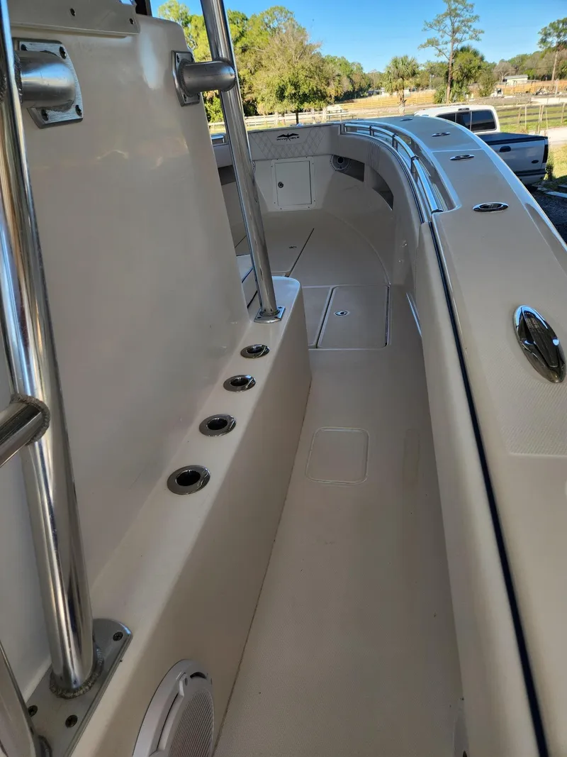 Slide: The Image of 2013 Invincible 36 Open Fisherman boat deck with rod holders and spacious walkway. - 35