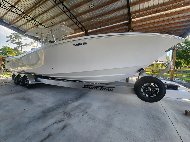 Slide: The Image of 2013 Invincible 36 Open Fisherman boat on Sport Trail trailer under a metal roof. - 36