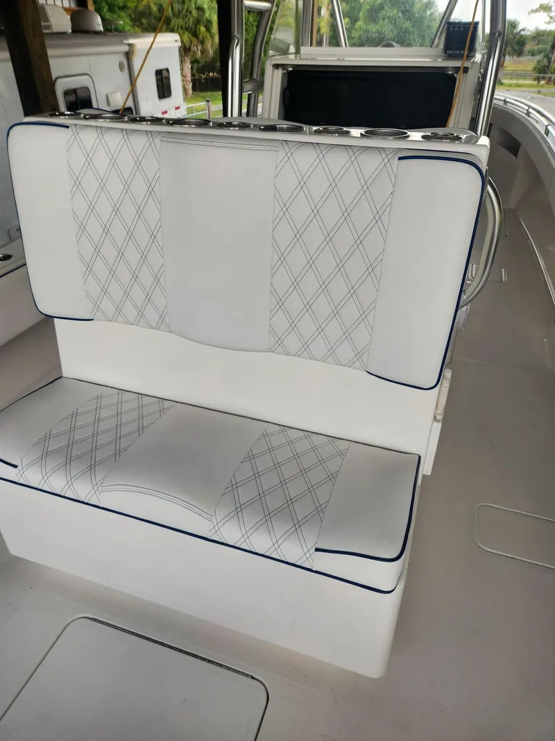 Slide: The Image of 2013 Invincible 36 Open Fisherman boat with white cushioned seating and diamond pattern design. - 39