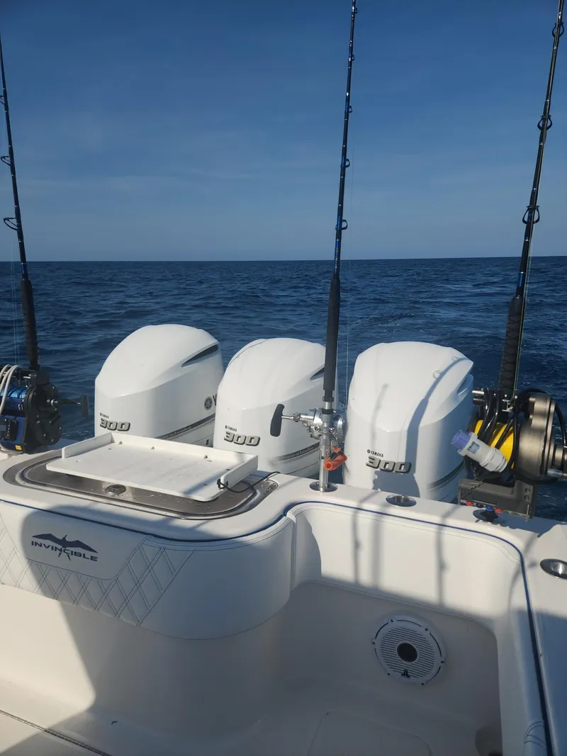 Slide: The Image of 2013 Invincible 36 Open Fisherman boat with triple engines and fishing rods on open sea. - 8