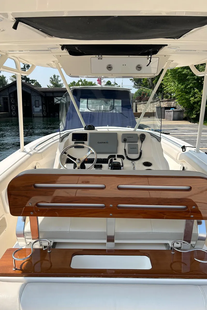 Slide: The Image of 2012 Pursuit S 280 Sport boat interior with wooden seating and steering console. - 10