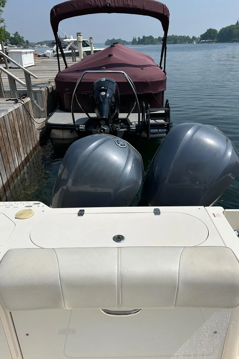 Slide: The Image of 2012 Pursuit S 280 Sport boat docked with twin engines, calm water background. - 11