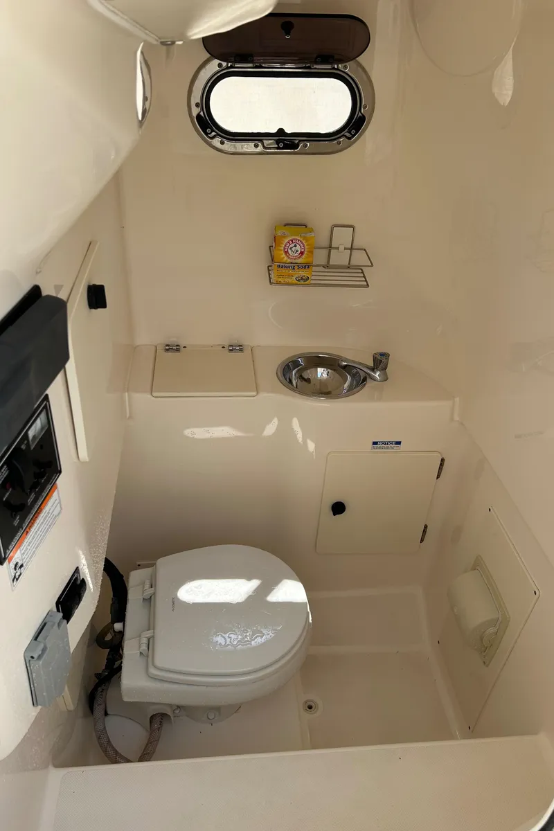 Slide: The Image of 2012 Pursuit S 280 Sport boat bathroom with toilet, sink, and window. - 12