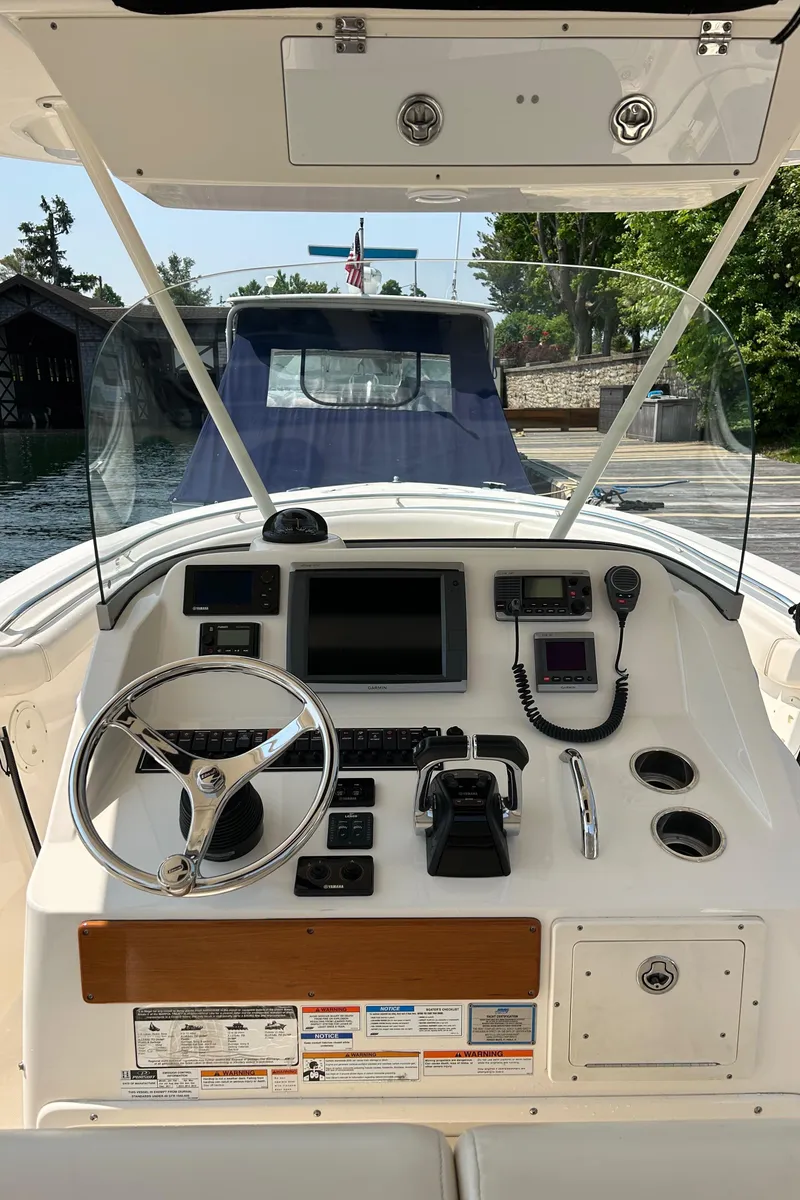 Slide: The Image of 2012 Pursuit S 280 Sport boat dashboard with steering wheel and navigation controls. - 8