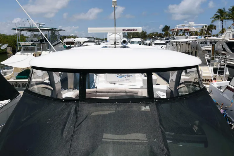 Slide: The Image of 2006 Sea Ray 52 Sundancer yacht docked at marina under clear blue sky. - 18