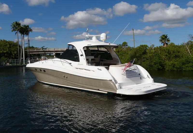 Slide: The Image of 2006 Sea Ray 52 Sundancer yacht cruising on a sunny day with lush greenery. - 3