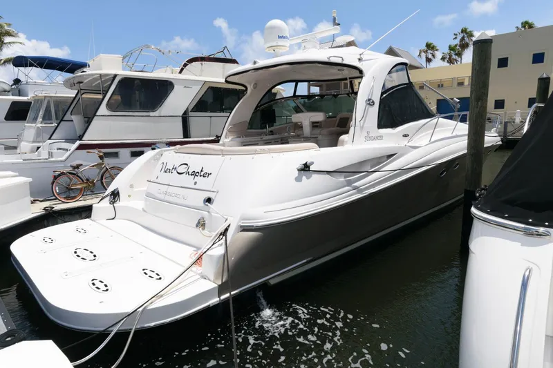 Slide: The Image of 2006 Sea Ray 52 Sundancer yacht docked at marina, featuring sleek design and spacious deck. - 5