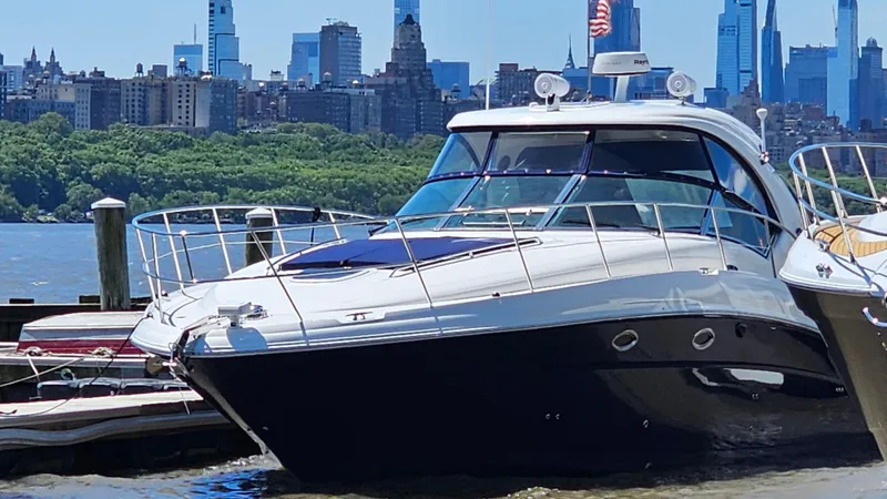 Slide: The Image of 2005 Sea Ray 390 Sundancer yacht docked with city skyline in background. - 0