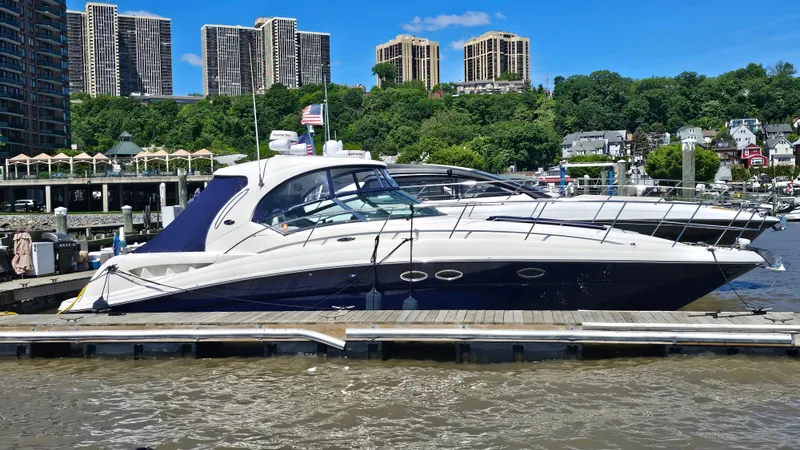 Slide: The Image of 2005 Sea Ray 390 Sundancer yacht docked at marina, city skyline in background. - 1