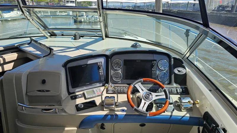 Slide: The Image of 2005 Sea Ray 390 Sundancer helm with modern navigation equipment and wooden steering wheel. - 13