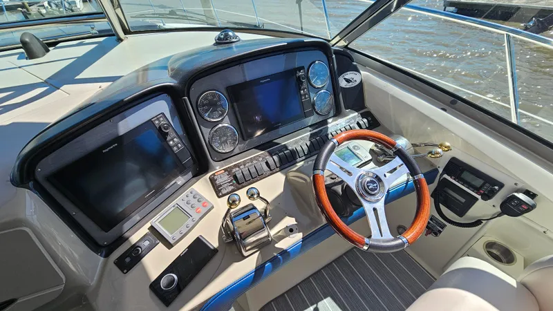 Slide: The Image of Helm of 2005 Sea Ray 390 Sundancer with modern navigation equipment and wooden steering wheel. - 15