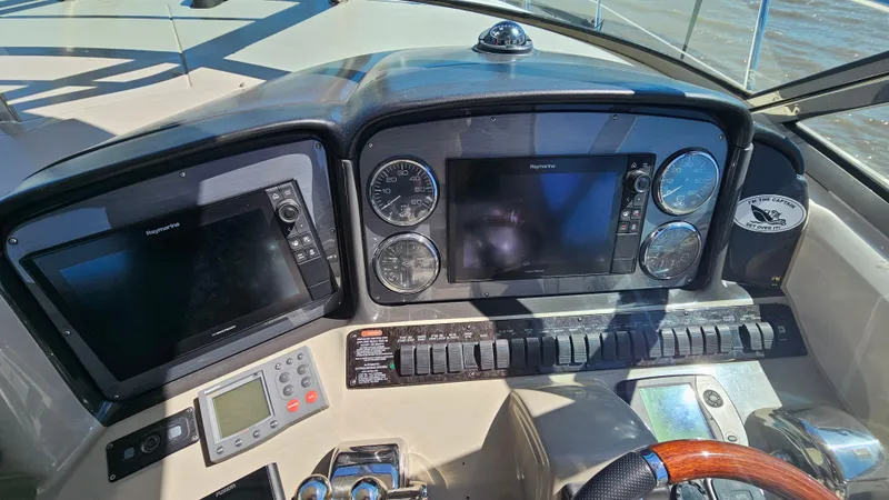 Slide: The Image of 2005 Sea Ray 390 Sundancer helm with navigation screens and controls. - 16