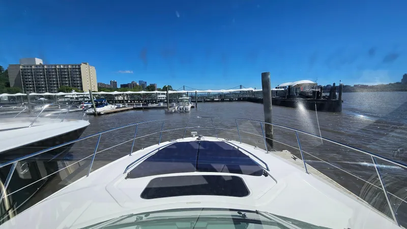 Slide: The Image of 2005 Sea Ray 390 Sundancer at marina, city skyline in background, clear blue sky. - 17