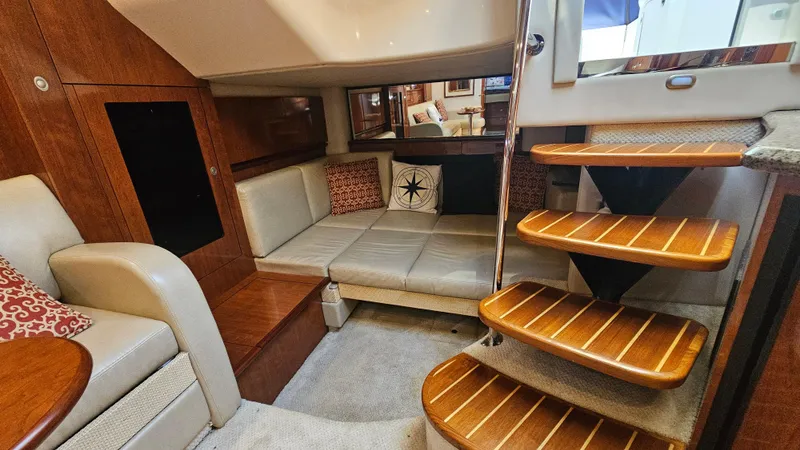 Slide: The Image of 2005 Sea Ray 390 Sundancer interior with cozy seating and wooden steps. - 21