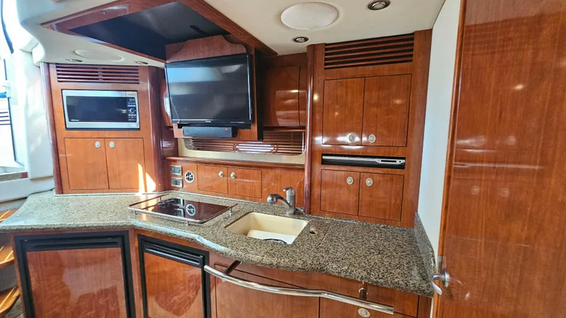 Slide: The Image of Luxurious 2005 Sea Ray 390 Sundancer yacht kitchen with wood cabinetry and modern appliances. - 27
