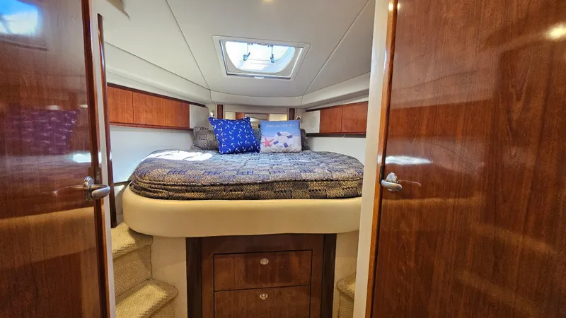 Slide: The Image of Luxurious cabin interior of 2005 Sea Ray 390 Sundancer with cozy bedding and wooden accents. - 33