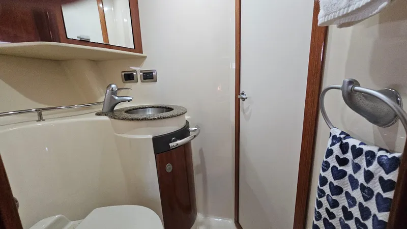 Slide: The Image of Bathroom interior of 2005 Sea Ray 390 Sundancer yacht, featuring sink and heart-patterned towel. - 35