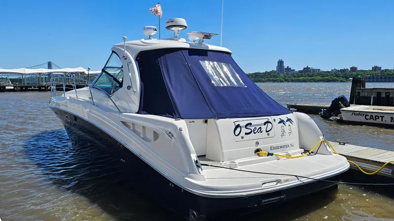 Slide: The Image of 2005 Sea Ray 390 Sundancer yacht docked, featuring sleek design and blue canopy. - 5