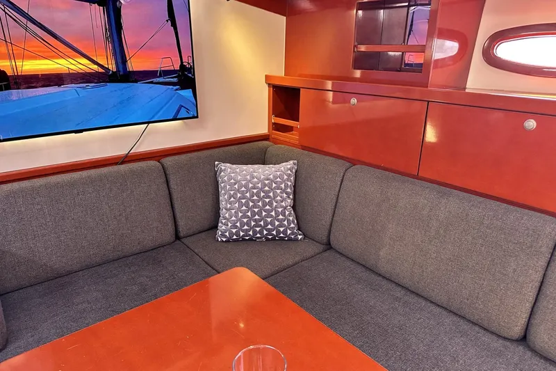 Slide: The Image of Interior of 2006 Hanse 461 yacht with cozy seating and sunset view on TV. - 12