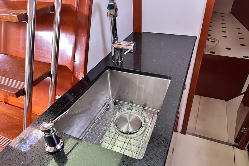 Slide: The Image of Modern kitchen sink on 2006 Hanse 461 yacht with sleek black countertop. - 16
