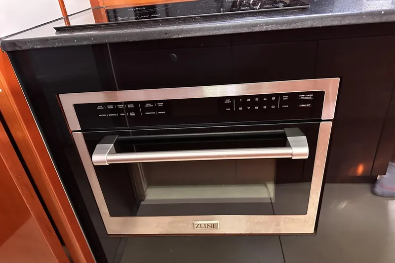 Slide: The Image of Modern kitchen with ZLINE oven, sleek black cabinetry, and granite countertop. - 18