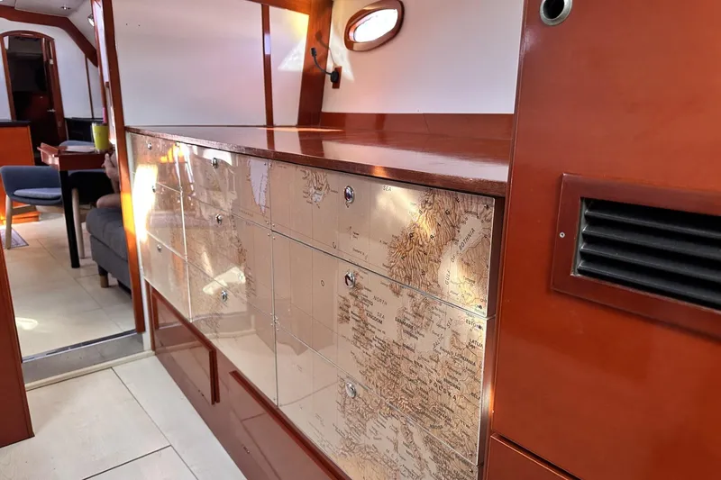Slide: The Image of Interior of 2006 Hanse 461 yacht featuring elegant wood cabinetry with map design. - 21