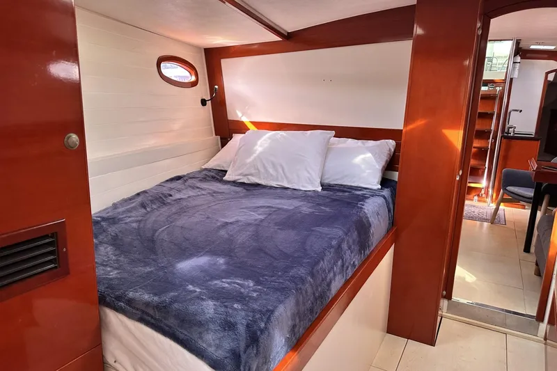 Slide: The Image of Cozy cabin interior of 2006 Hanse 461 yacht with plush bedding and wooden accents. - 22