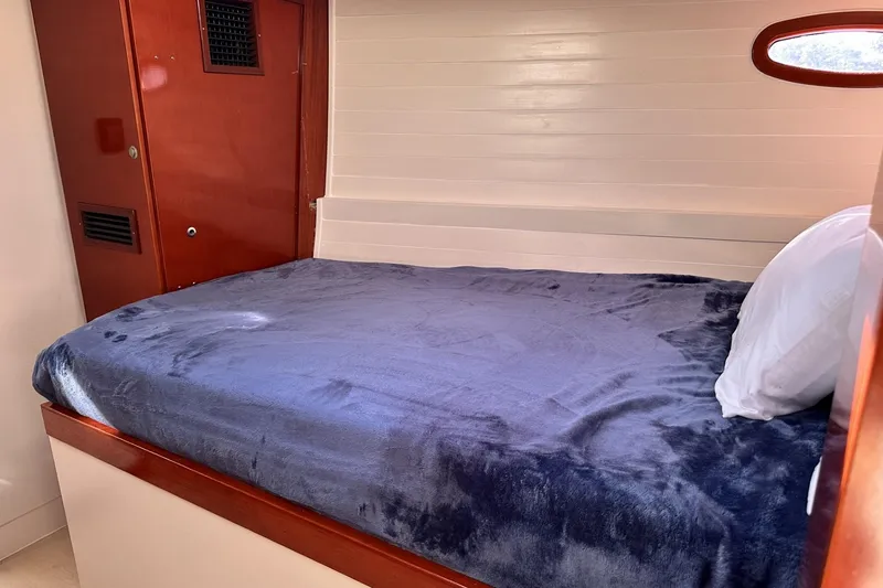 Slide: The Image of Cozy cabin bed in 2006 Hanse 461 yacht with wooden interior and porthole. - 23