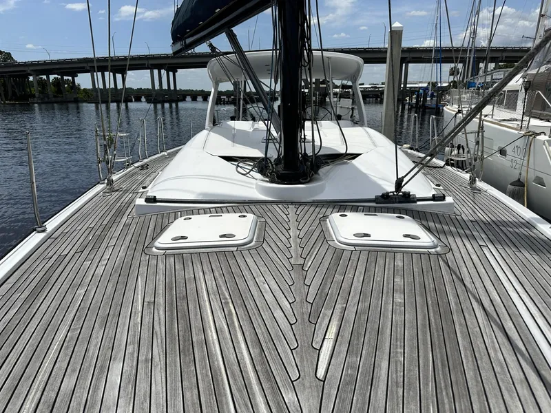 Slide: The Image of 2006 Hanse 461 sailboat deck with wooden finish, docked near a bridge. - 28