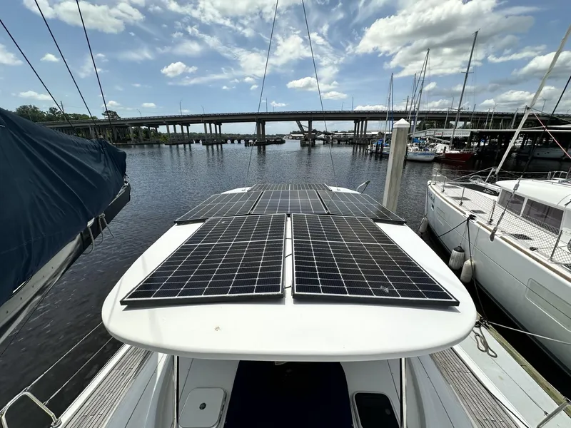 Slide: The Image of 2006 Hanse 461 yacht with solar panels docked at a marina under a cloudy sky. - 31