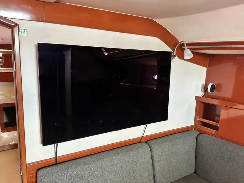 Slide: The Image of Interior of 2006 Hanse 461 yacht with mounted TV and gray sofa. - 38