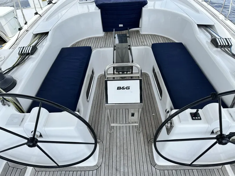 Slide: The Image of Cockpit of 2006 Hanse 461 yacht with dual steering wheels and blue cushioned seating. - 5