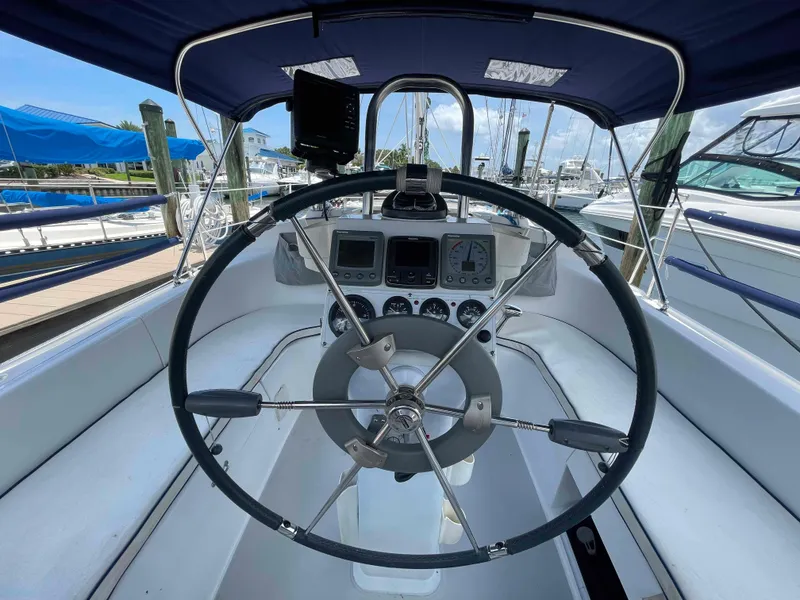 Slide: The Image of Steering wheel and dashboard of a 2006 Hunter 309 sailboat at a marina. - 10