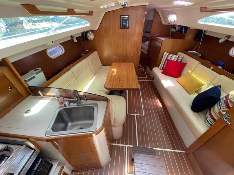 Slide: The Image of Luxurious 2006 Hunter 309 yacht interior with wood finish, cozy seating, and modern kitchen amenities. - 2