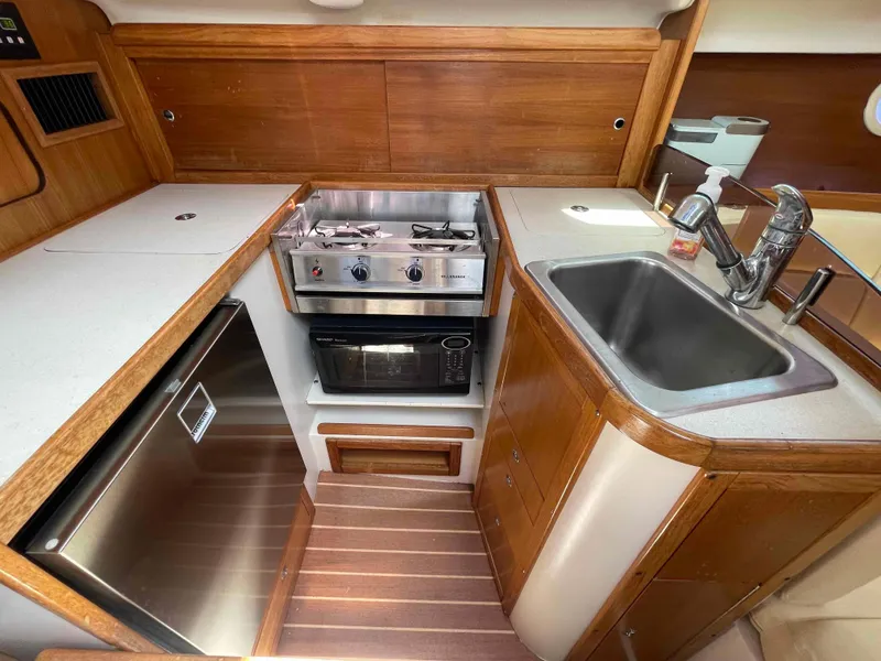 Slide: The Image of Compact kitchen in a 2006 Hunter 309 yacht with stove, sink, and microwave. - 24